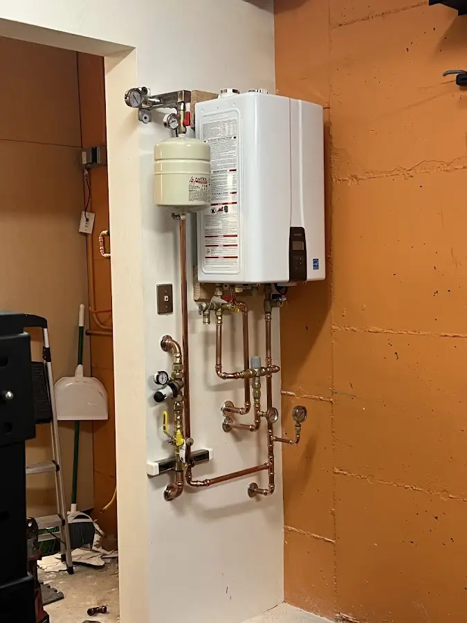 Plumbing technician inspecting water heater connections in Wallkill